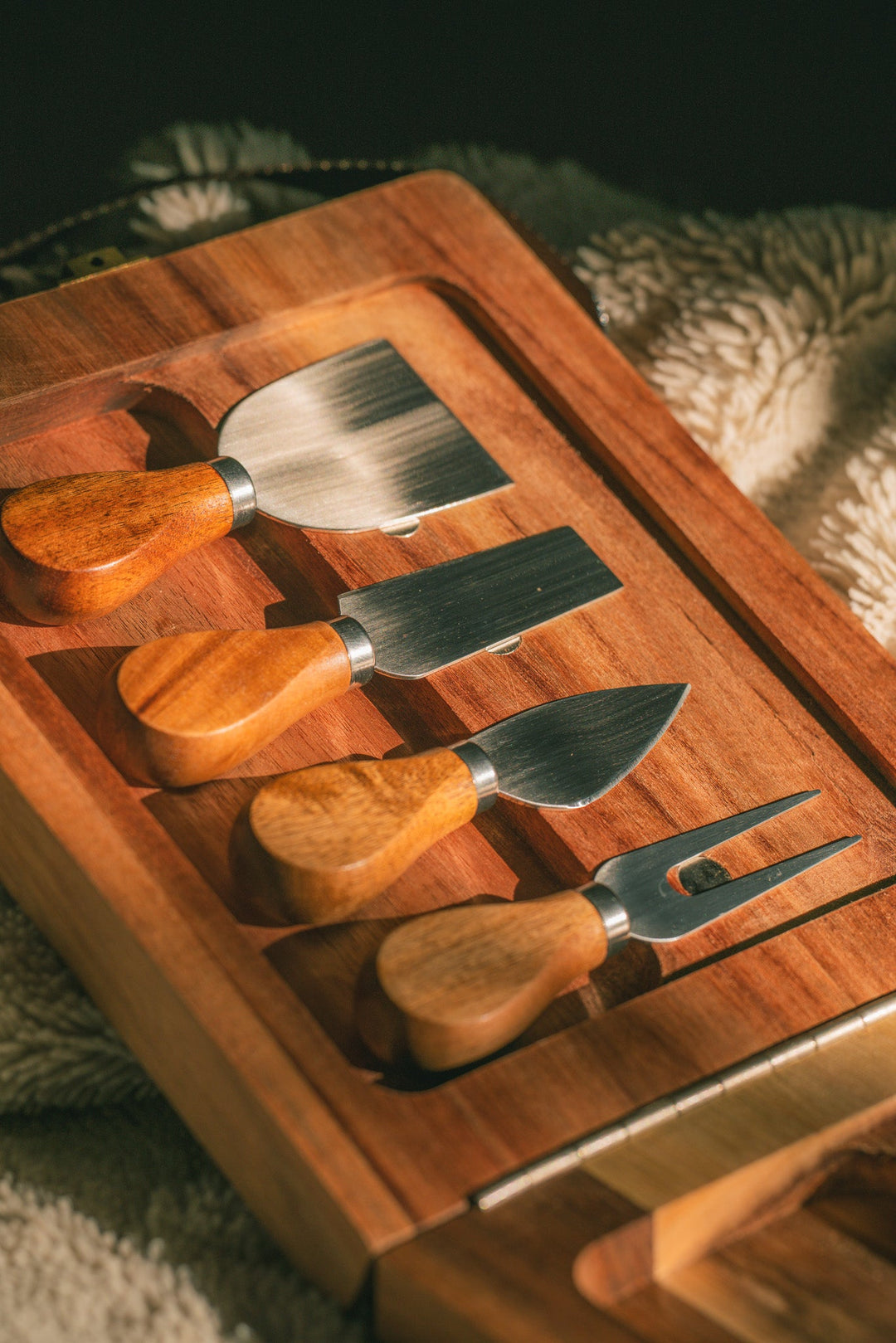 Wooden folding cheese board with cheese tools and dark webbing straps