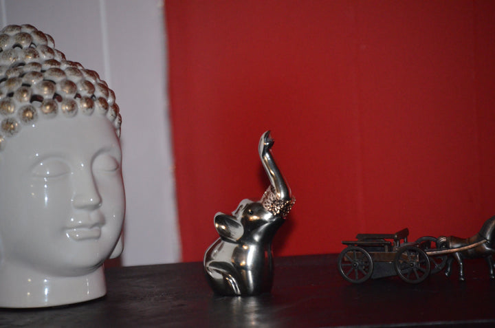 Metal elephant ring holder with red accents, raised trunk, decorative display