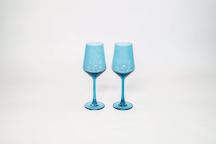 Two blue tinted stemmed wine glasses standing side by side, clear stems.