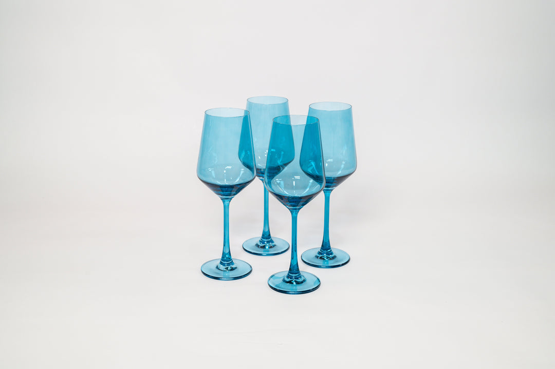 Four blue tinted stemmed wine glasses in a staggered arrangement, clear stems.