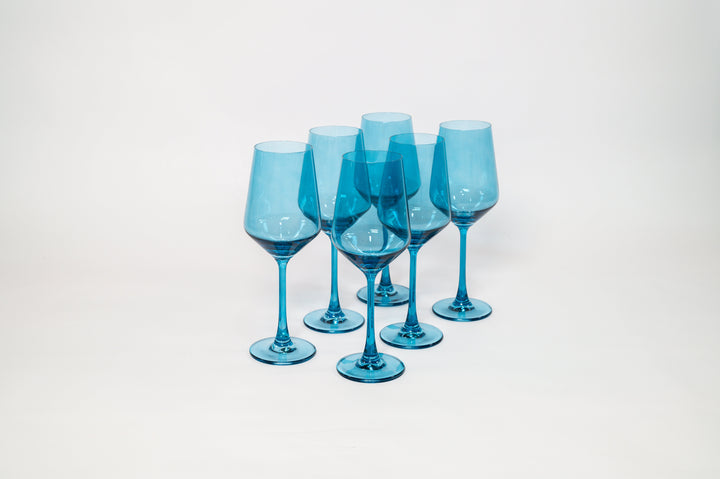 Six blue tinted stemmed wine glasses with rounded bowls and clear stems.