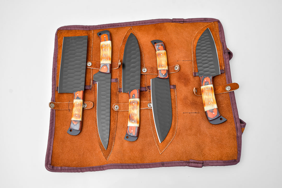 Burnt bone leather knife roll open, holding five knives with dark gray blades and orange handles