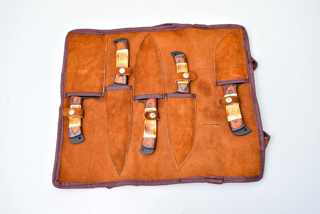 Open leather knife roll with five fixed knives in organizer pockets; orange handles, dark blades