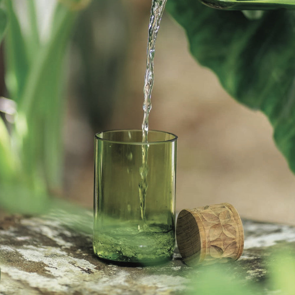 Set of 2 tall green drinking glasses, one with water pouring and one with wooden cap