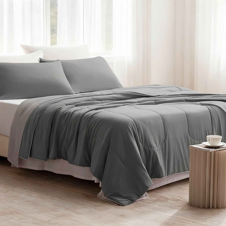 Dark gray cooling comforter set on bed with matching shams