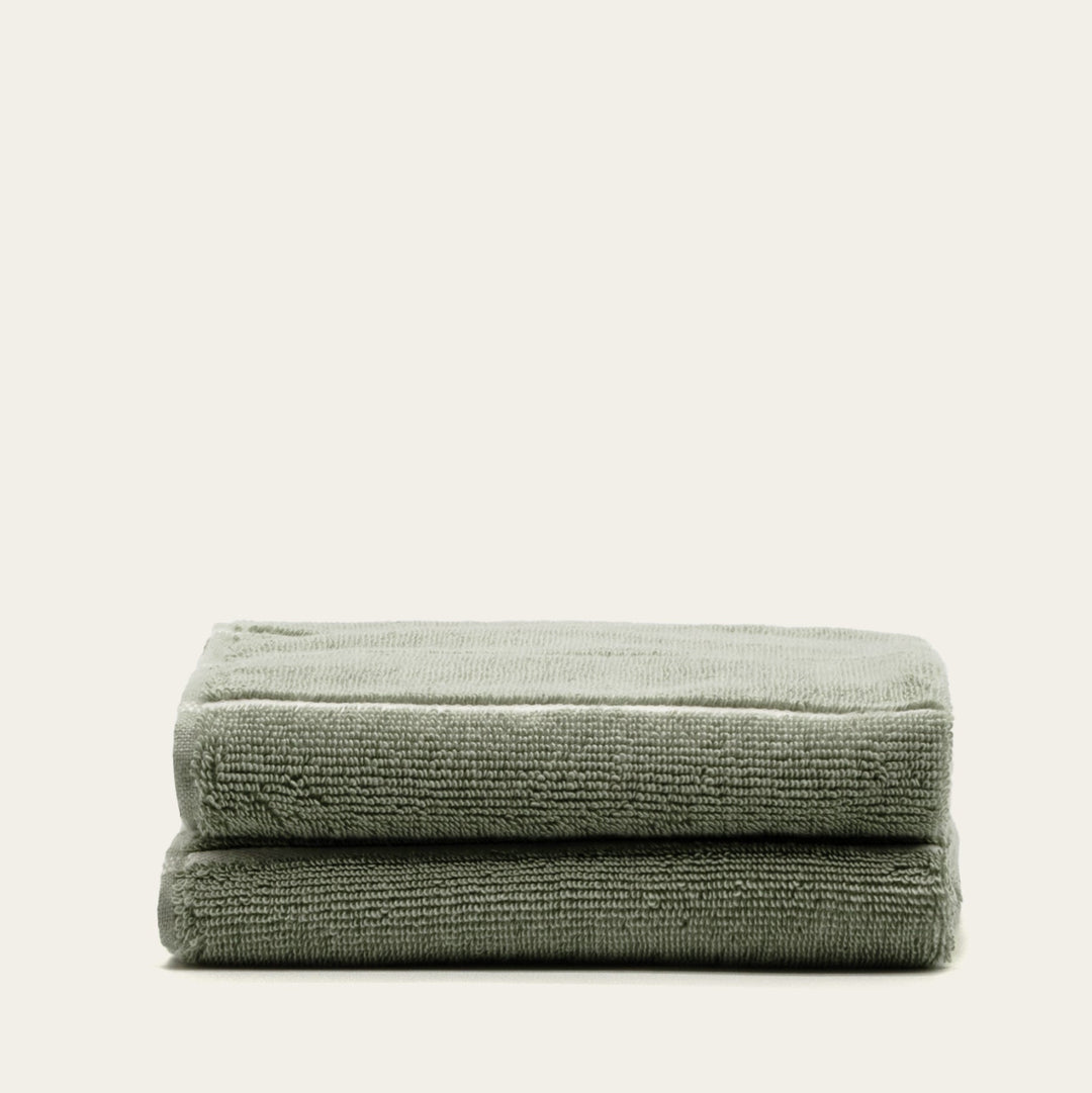 Sage green cotton towel stack with folded edges