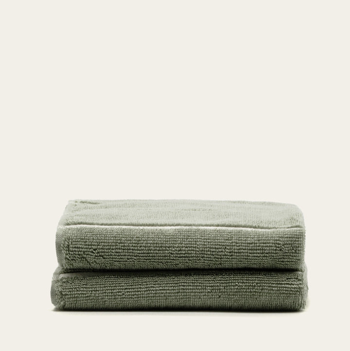 Sage green cotton towel stack with folded edges