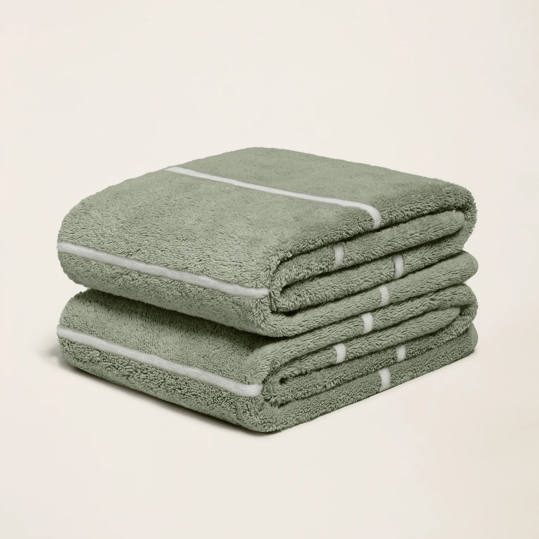 Sage green cotton towel with ecru striped band, folded in a stack