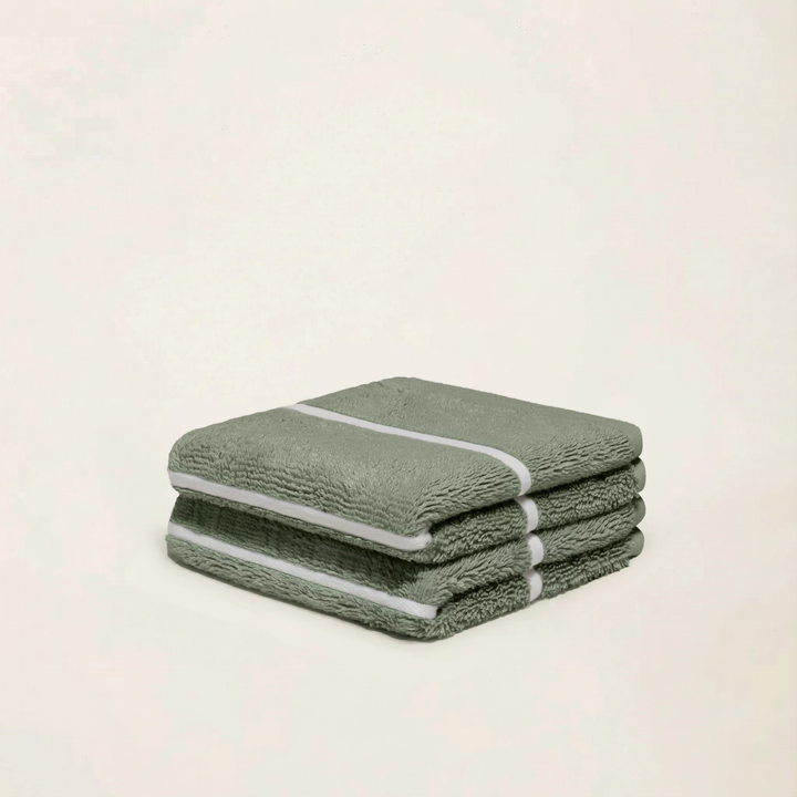 Stacked sage green cotton towels with ecru stripe detail