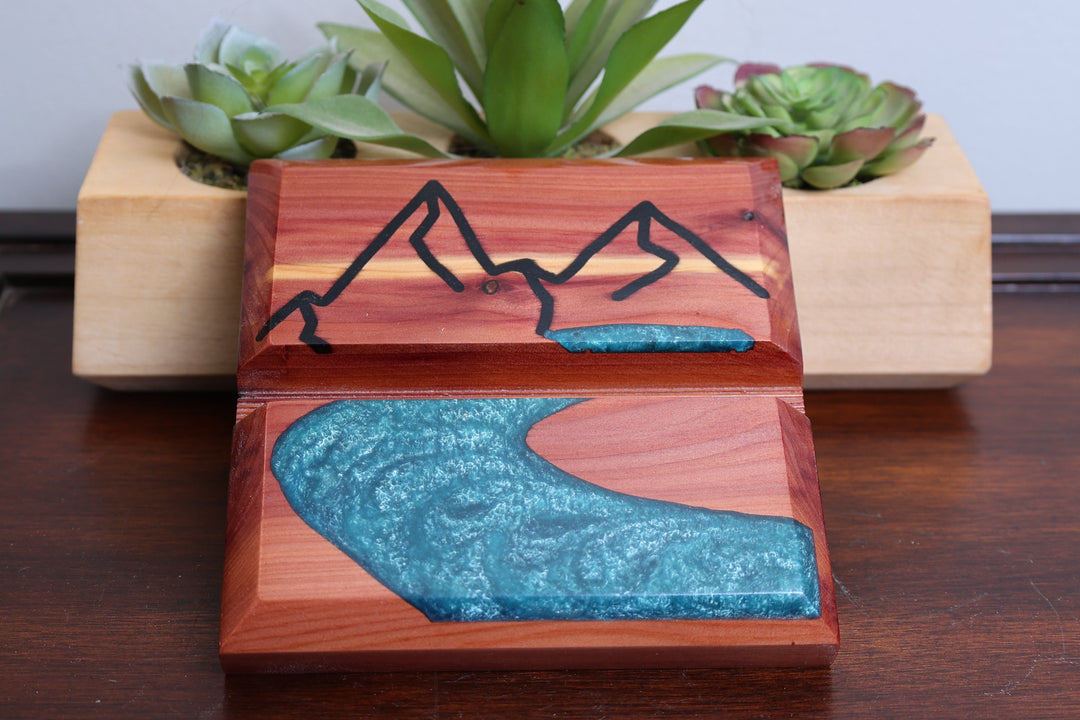 Wood and resin device holder with blue river wave and etched mountain detail