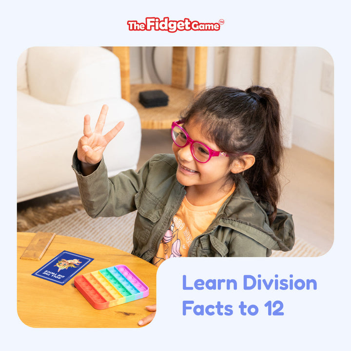 Child learning division with flashcards at a table, with the card pack nearby