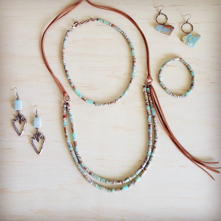 Turquoise and tan barrel-bead stretch bracelet with red-brown leather cord detail