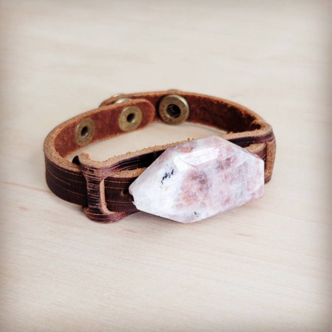 Brown leather cuff bracelet with pink-white crystal centerpiece and metal eyelets