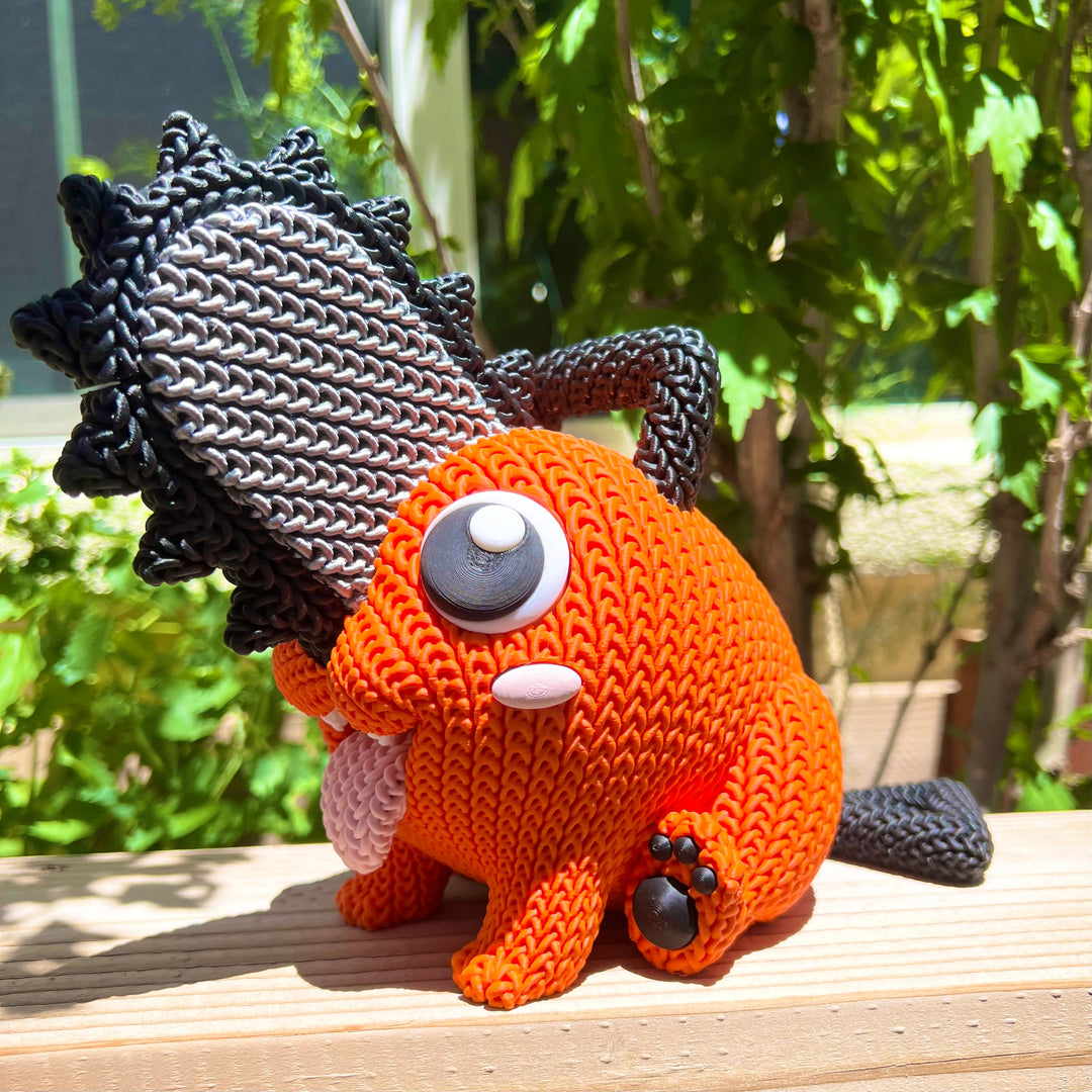 Knitted orange plush with black mane, gray button eye, white patch details, curled tail