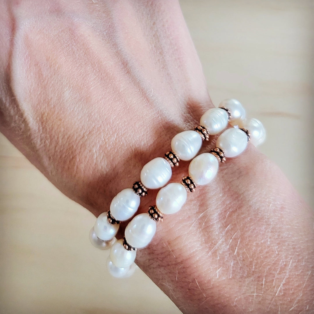 Freshwater pearl and copper beaded double-strand bracelet on wrist with round pearl beads