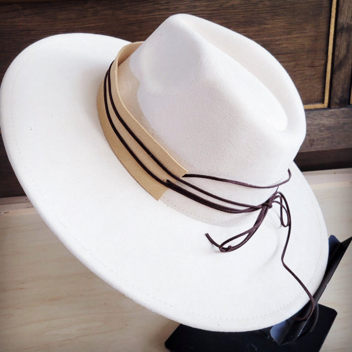 Wide-brim felt hat with tan suede band, dark trim, and long lace ties