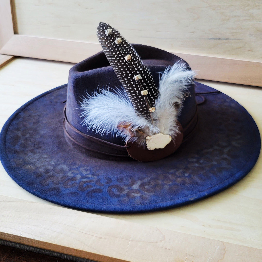 Navy blue leopard-print felt cowgirl hat with feathered beaded band