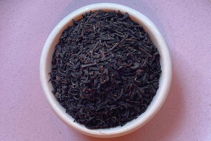 Earl Grey loose leaf tea leaves in a white ceramic bowl