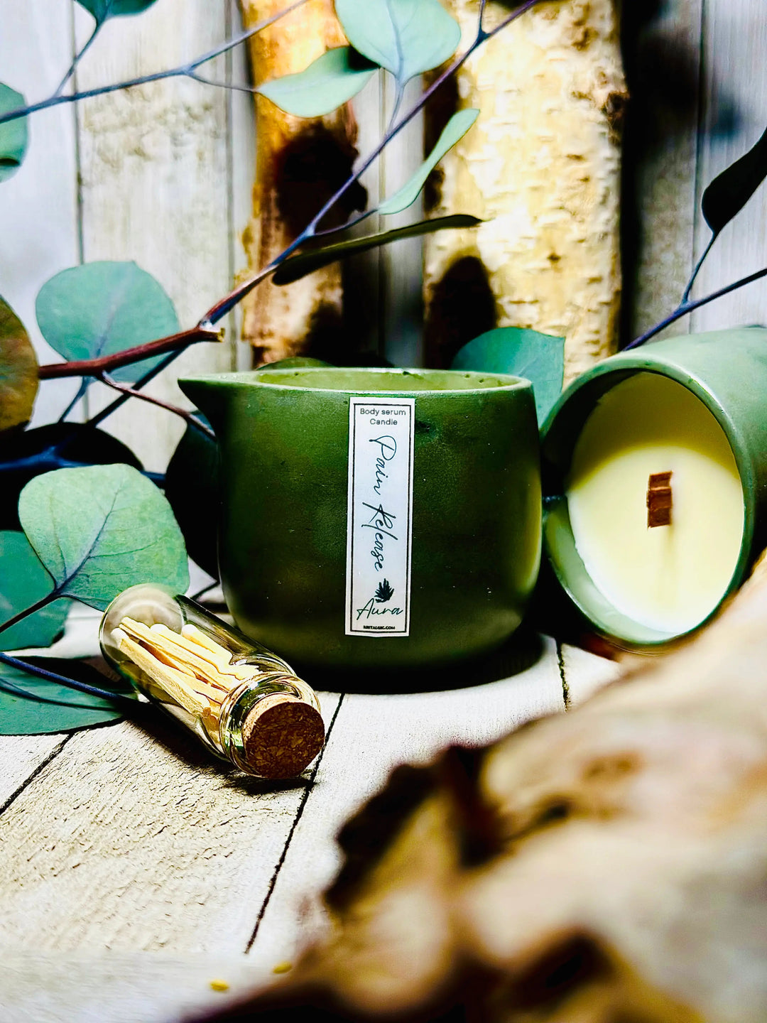 Pain-relieving bath oil set with green jar candle and gold-capped bottles