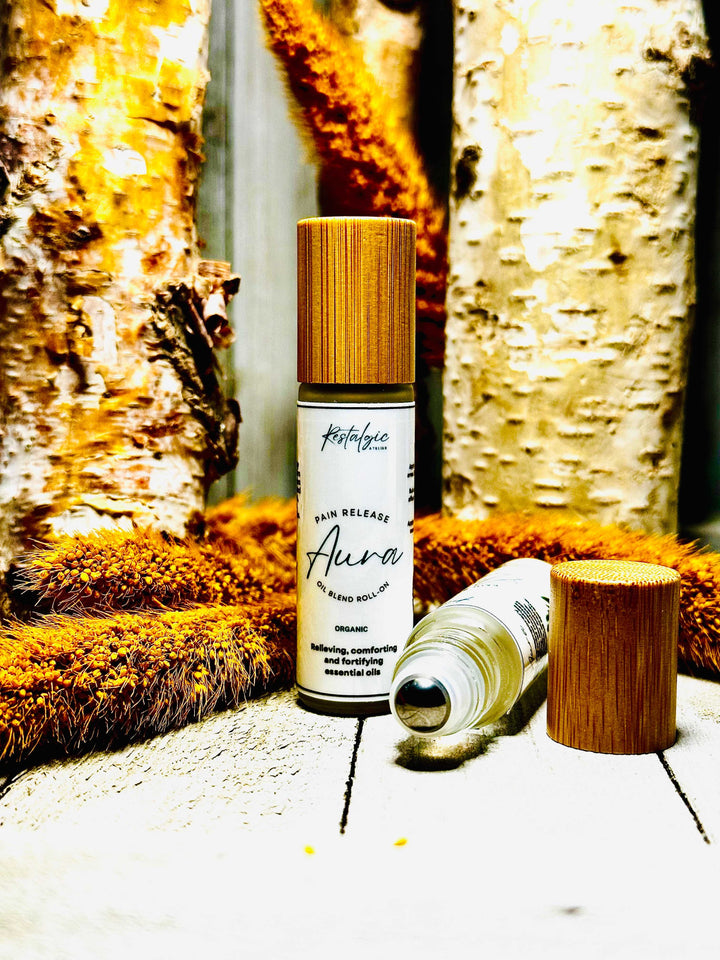 Pain-relieving essential oil bottles with gold caps and small wooden tins