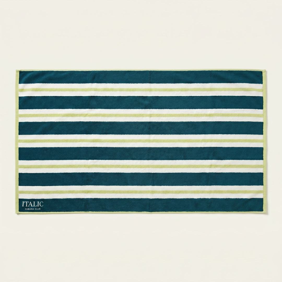 Cotton beach towel with navy and white horizontal stripes, teal binding, ITALIC tag