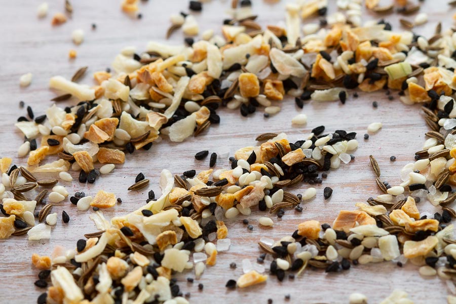Everything bagel spice seasoning mix with sesame, poppy, and salt on wooden surface