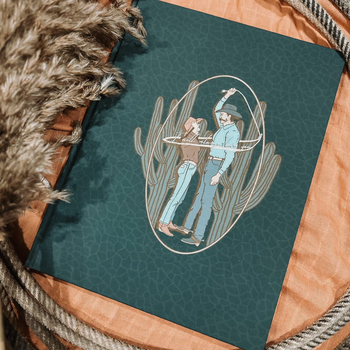 Teal date night memory book with illustrated cowboy and cactus outline on the cover