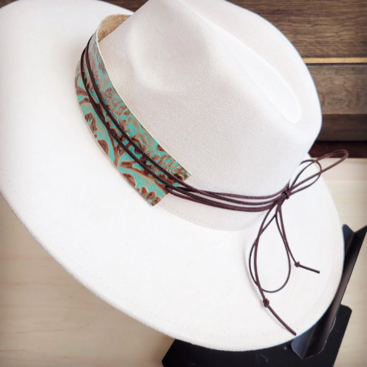 Turquoise leather cowboy hat band with embossed swirl pattern and dangling dark tie cords