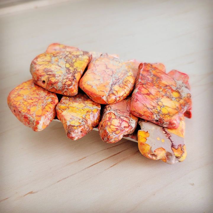 Orange Regalite stone slab pieces for belt buckle, assorted rounded cuts