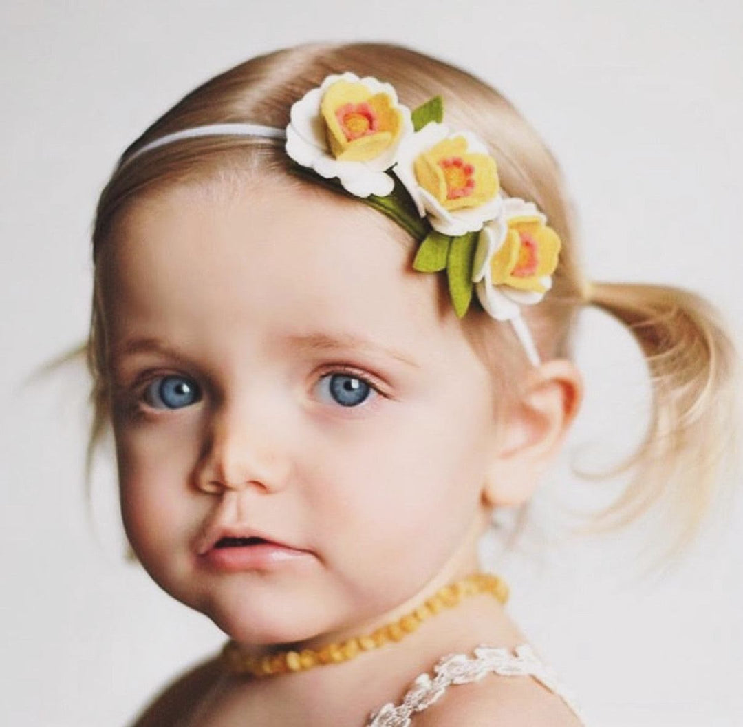 Amber bead necklace worn around a toddler's neck