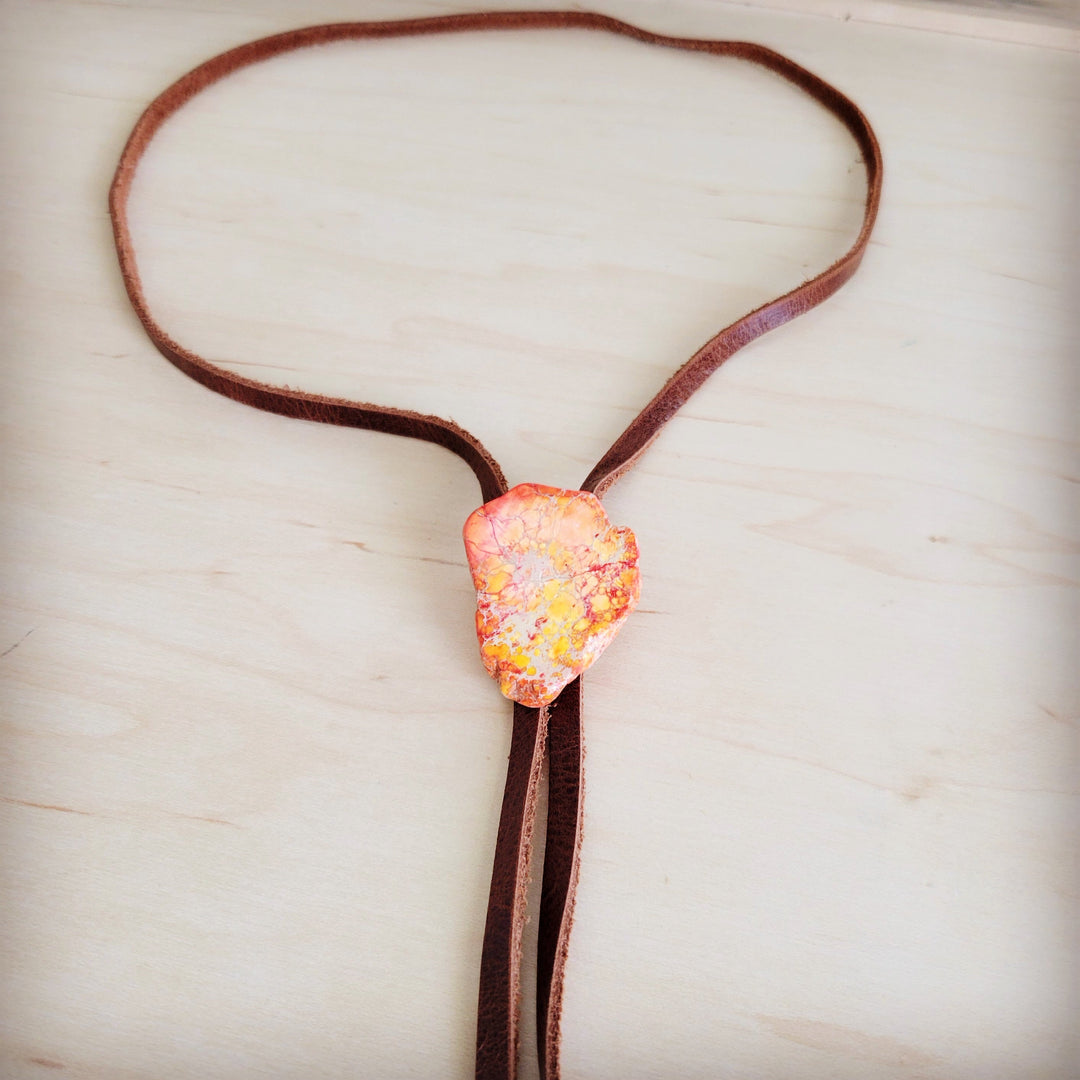 Orange Regalite slab pendant with two brown leather lariat ends