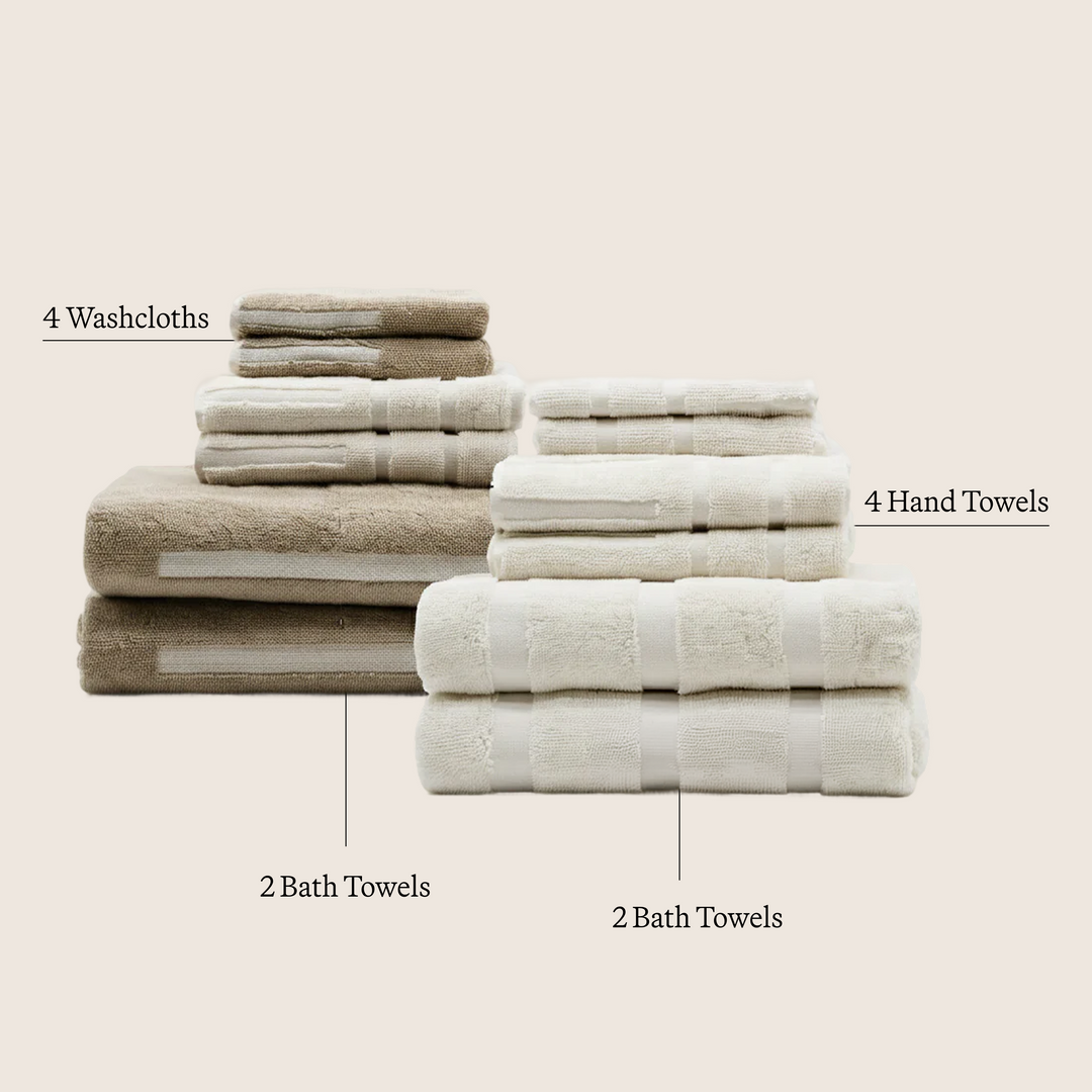 Folded cream and taupe cotton towels set with coordinating textures.