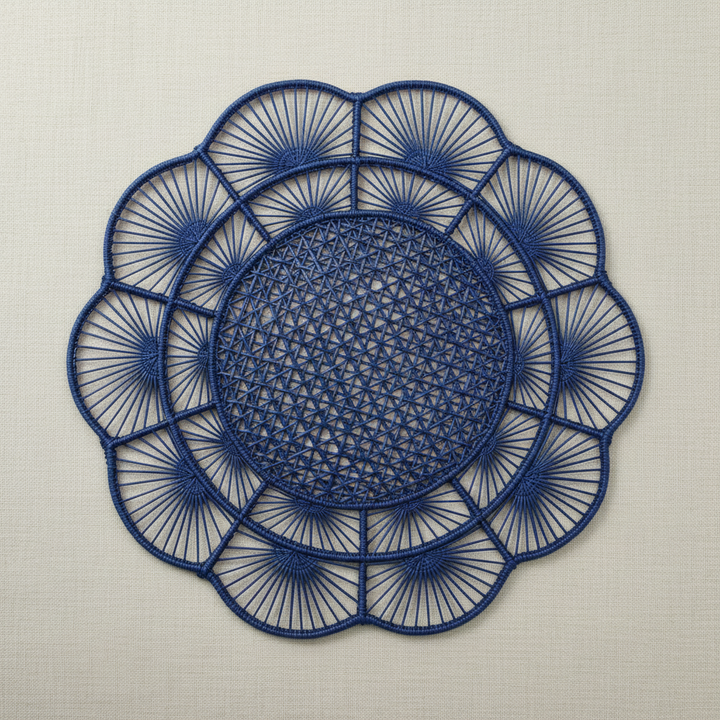 Handwoven iraca placemat in navy blue with dark center, lighter petals, and blue border