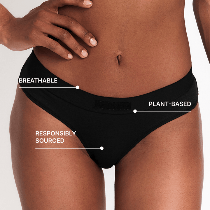 Black mid-rise brief close-up on waistband and leg edge; breathable plant-based design.