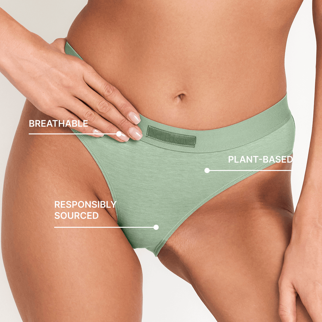 Sage green mid-rise briefs showing waistband and centered back seam on model