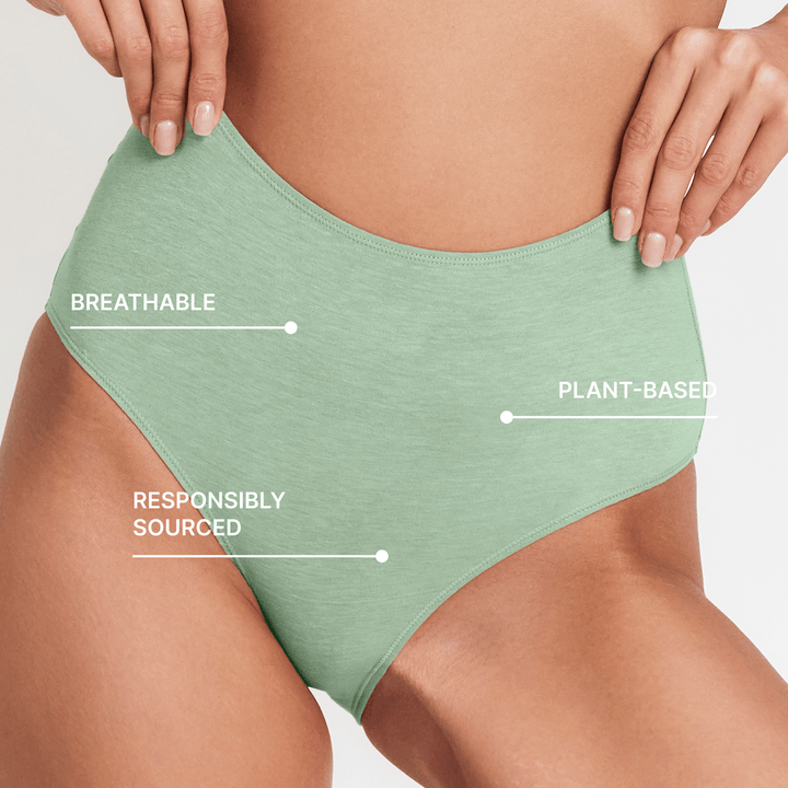 High-rise brief in light green with smooth fabric, high waist, and curved front panel detail.