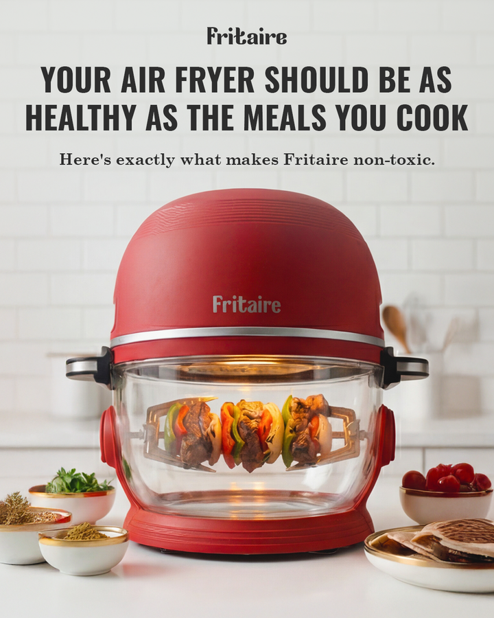 Red Fritaire air fryer with clear glass bowl filled with cooked food