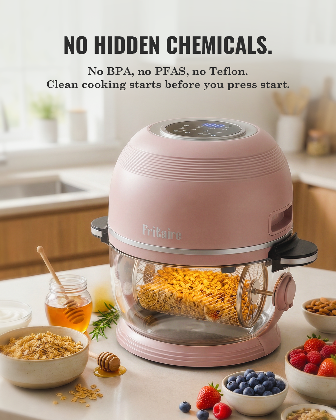 Light pink air fryer with clear glass basket, handle, and visible golden food inside