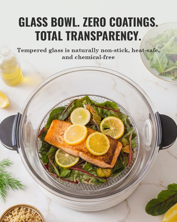 Clear glass air-fryer basket filled with fish fillets, lemon slices, and greens