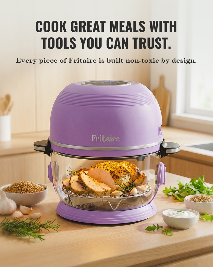 Purple air fryer with clear glass basket and seasoned chicken with herbs inside