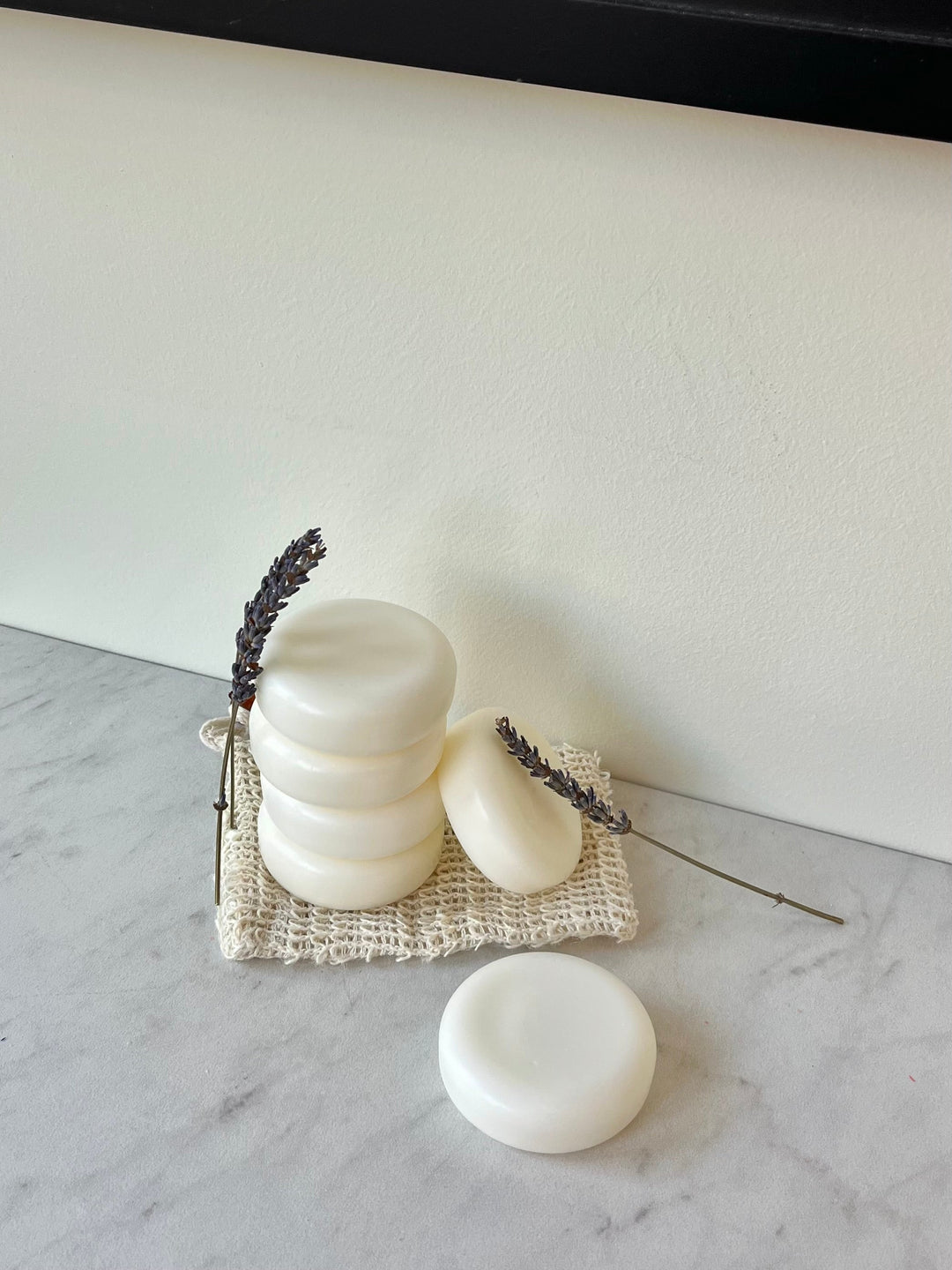 Solid conditioner bar with stacked white rounds and a small bar on a woven pad