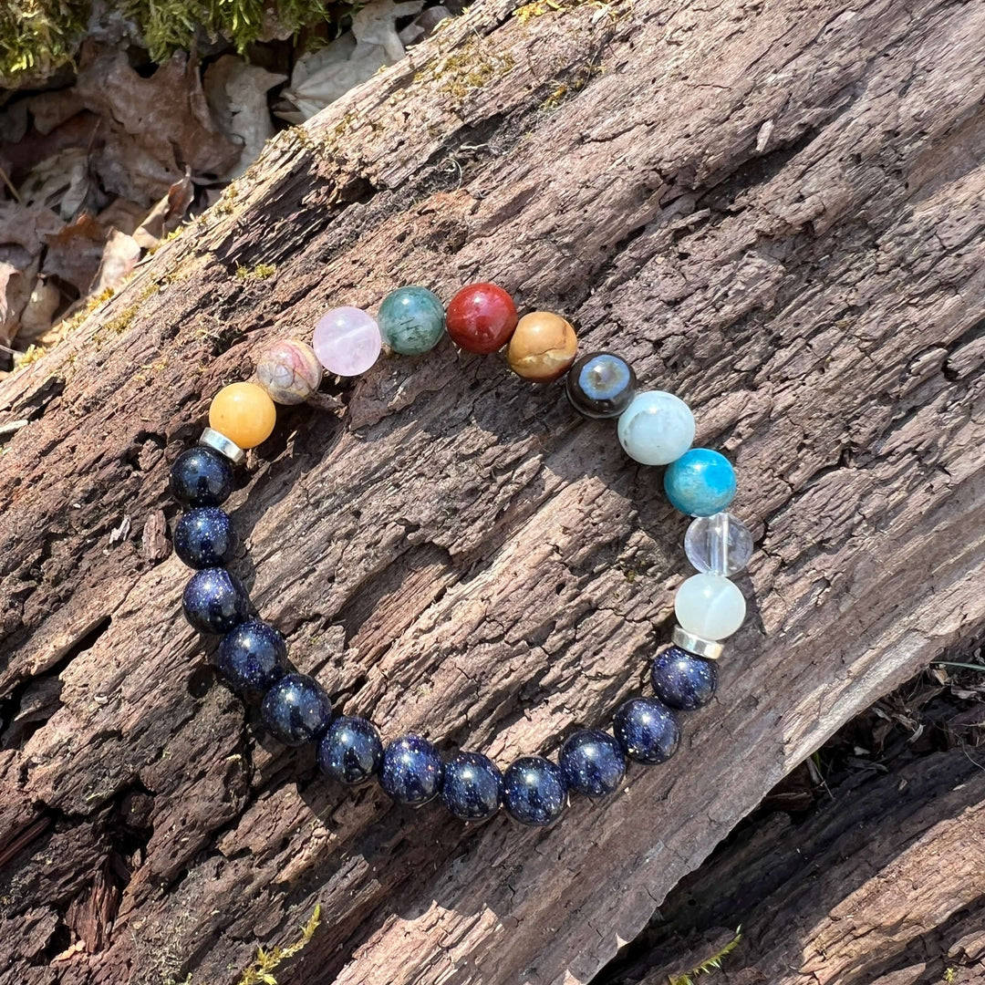 Beaded solar system bracelet with dark blue galaxy beads and clear, aqua, and red planet beads