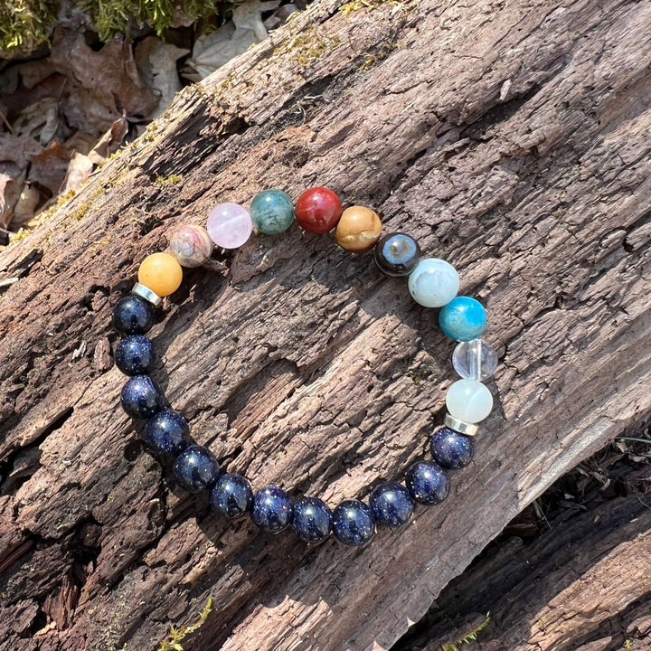 Beaded solar system bracelet with dark blue galaxy beads and clear, aqua, and red planet beads