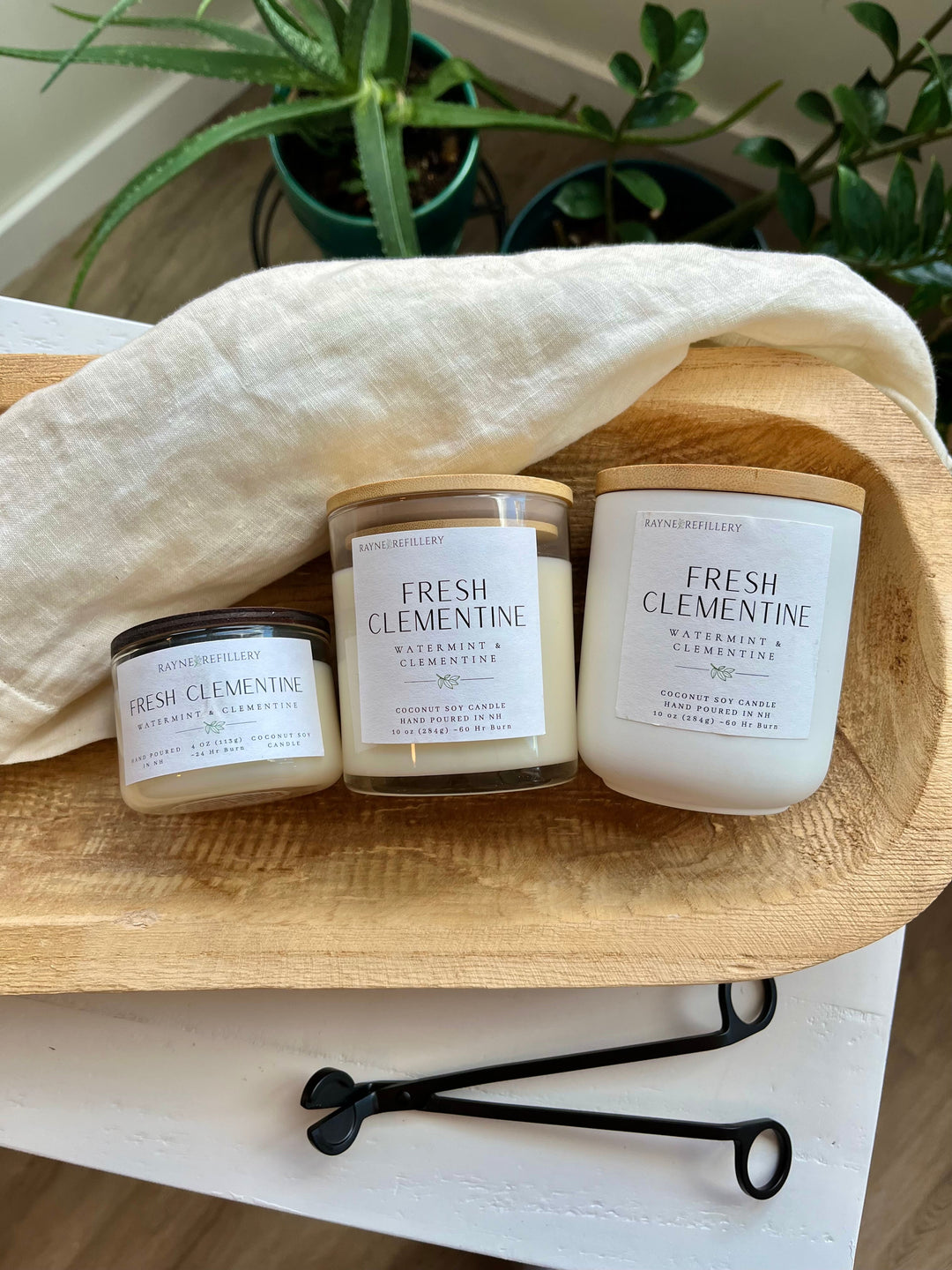 Three coconut soy candles with Fresh Clementine labels in glass jars on wooden tray