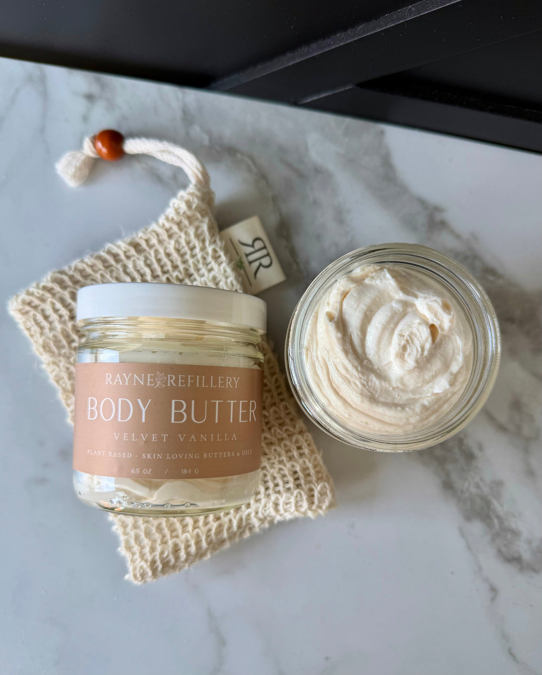 Body butter jar with creamy swirl, velvet vanilla label on beige jar