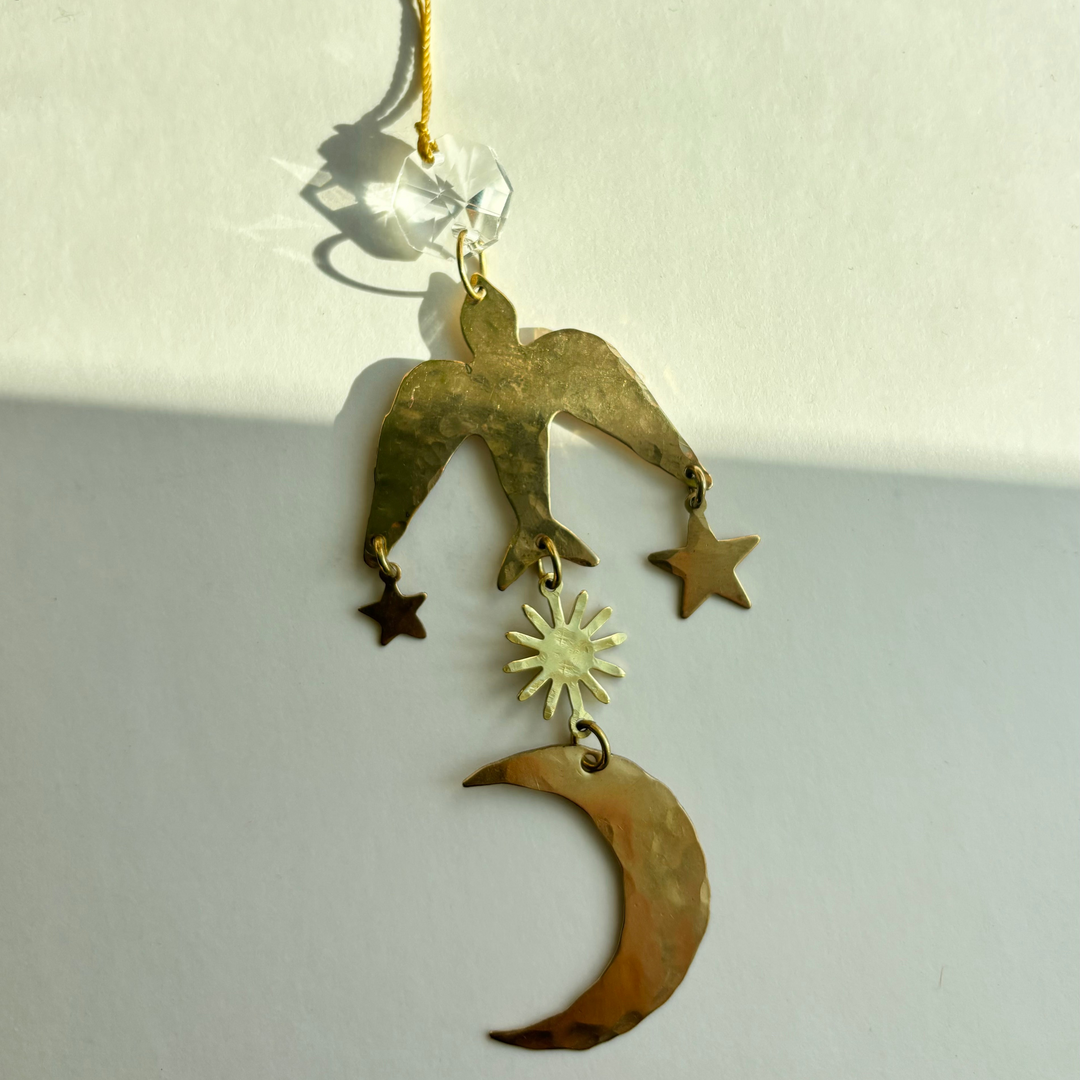 Gold-toned hanging ornament with moon, stars, and sunburst crystal charm