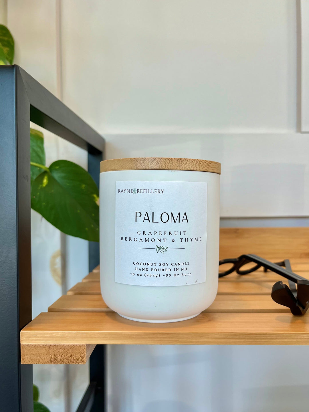 Coconut soy candle in white jar with wood lid on a wooden surface; label shows grapefruit & thyme