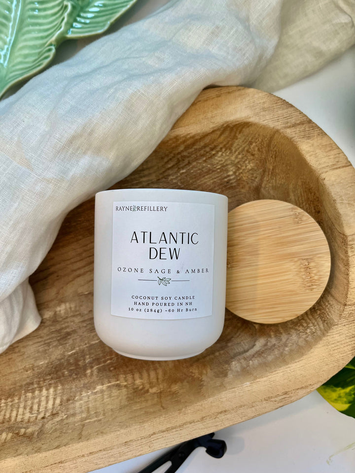 Coconut soy wax candle in a white jar with wooden lid on a wood tray