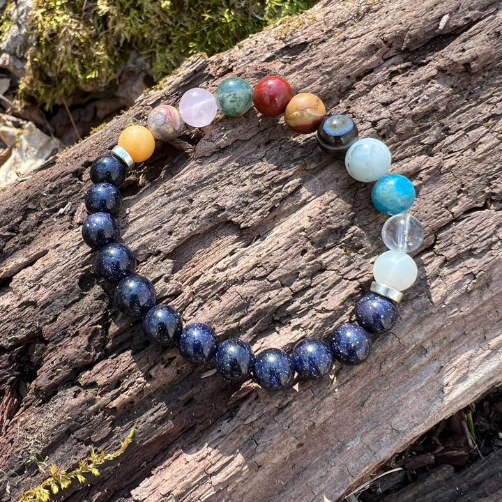 Beaded solar system bracelet with dark blue galaxy beads and multicolor planet stones