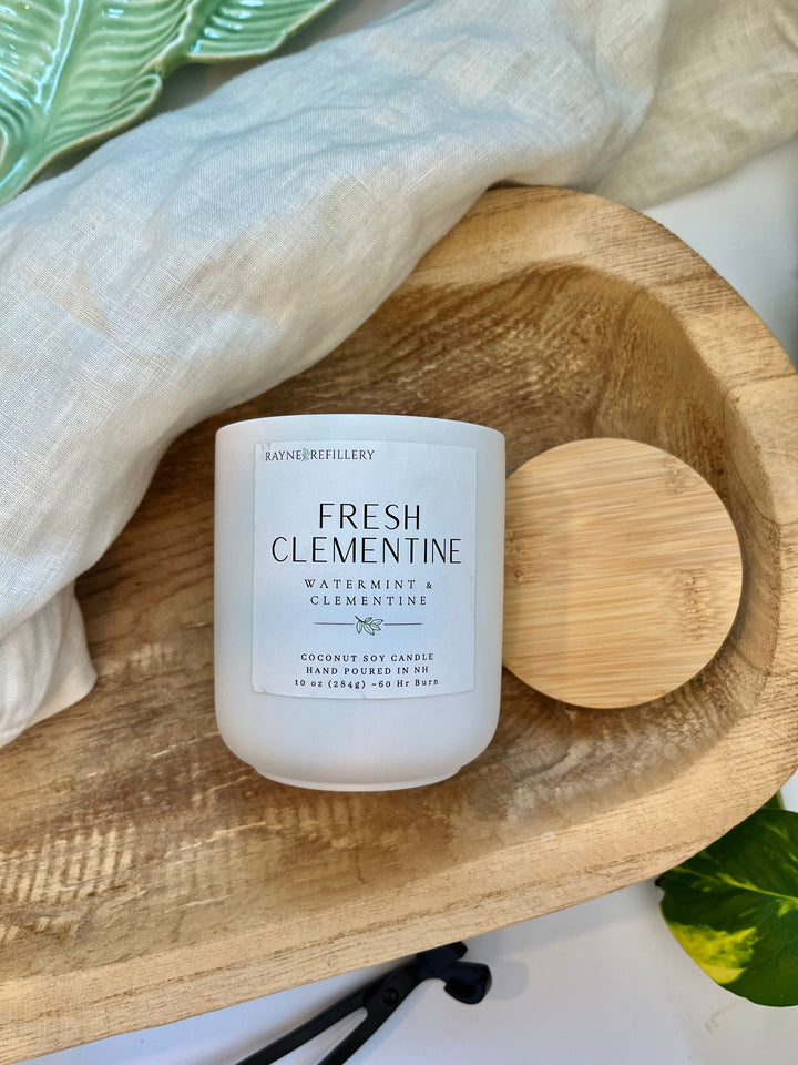 Coconut soy candle in frosted glass jar with Fresh Clementine label and wooden lid